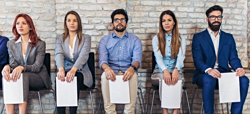 Personas esperando con su currículum a una entrevista de trabajo