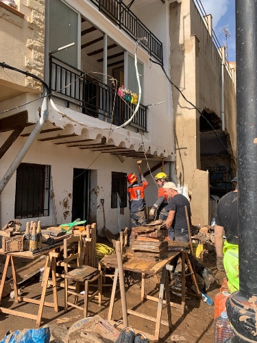 Vecinos retirando enseres acompañados de los bomberos que analizan el estado de las viviendas