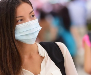 Chica con mascarilla en un aeropuerto, en dirección a su programa de Erasmus +