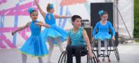 Coreografía de niños y niñas bailando, dos de ellos en silla de ruedas